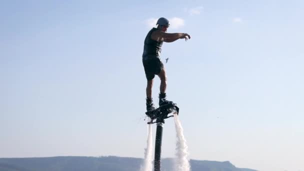 Flyboarding is a new extreme water sport. Athletic man performs tricks in flight. Spectacular sports coups and turns. — Stock Video