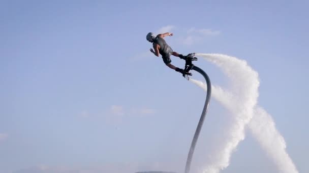 Flyboardingu je nový extrémní vodní sport. Atletický muž provádí triky v letu. Velkolepé sportovní převraty a zatáčky. — Stock video