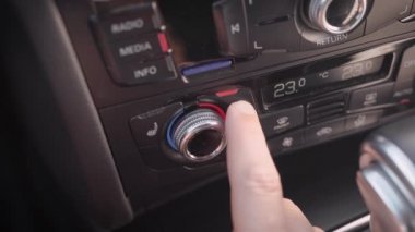 Çerçevede, erkek eli ve arabanın iklim sistemi. Adam kabinde klima, sıcaklık, konfor ayarlar.