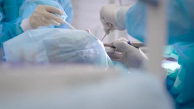 Diş kliniğinde ciddi bir ameliyat. Cerrah hastaya protez yerle bir eder. Mükemmel stil için koşullar yerine getirilir.