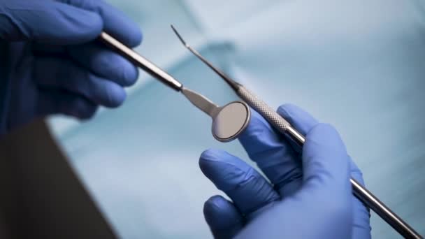 Un dentiste en gants tient un outil de diagnostic . — Video