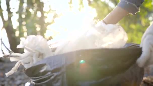 El hombre irreconocible recoge la basura que yace en la naturaleza. Desafortunadamente, mucha basura y contaminación están ahora en el bosque, el paseo marítimo y la naturaleza. Voluntarios — Vídeos de Stock