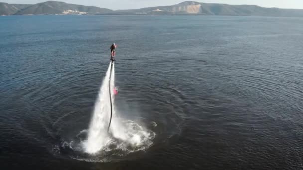 Energisk man flyger på Jet Pack över vatten — Stockvideo
