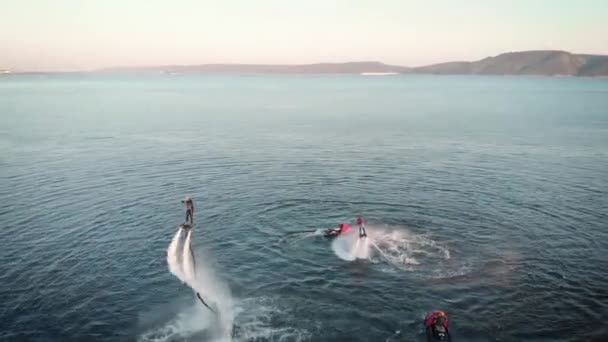 Gente deportiva volando sobre el agua con mochilas — Vídeos de Stock