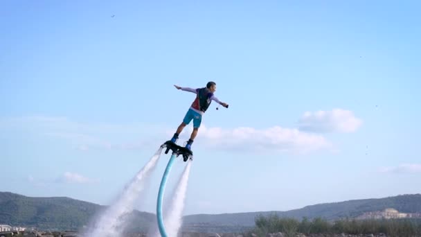 Adventurous man hovering on jet pack over sea — Stock Video