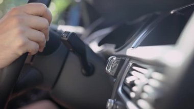 Bir adam bir arabanın direksiyonuna dokunur. Bir iş adamı bir yere gitmek üzere. Araba ile çalışmak için yol.
