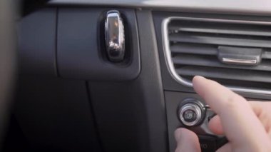 Çerçevede, bir adamın eli ve bir araba ses ses kolu. Sürücü veya yolcu müziğin ses düzeyini ayarlar.