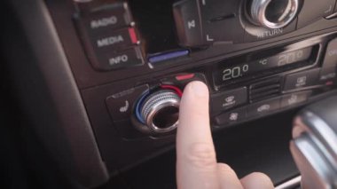 Çerçevede, erkek eli ve arabanın iklim sistemi. Adam kabinde klima, sıcaklık, konfor ayarlar.