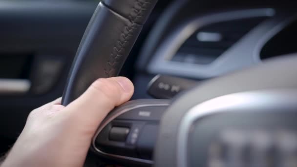 Ein Mann fährt Auto. Im Rahmen befindet sich ein Multilenkrad, mit dem man die Fahrzeugparameter direkt während der Fahrt über die Tasten und den Joystick steuern kann.. — Stockvideo