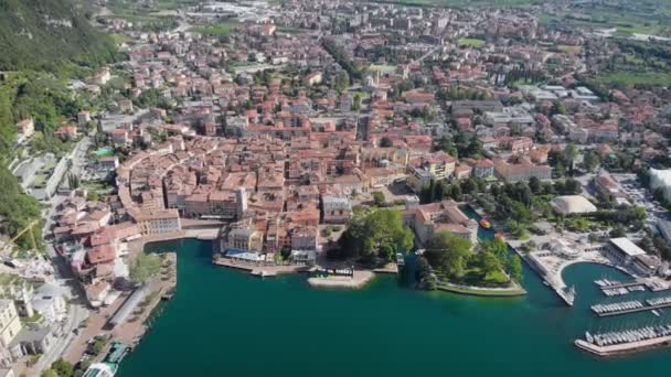 हवाई दृश्य। उत्तरी इटली में एक रिसॉर्ट शहर रिवा डेल गार्डा। शहर का मध्ययुगीन हिस्सा गार्डा झील के तट पर स्थित है — स्टॉक वीडियो