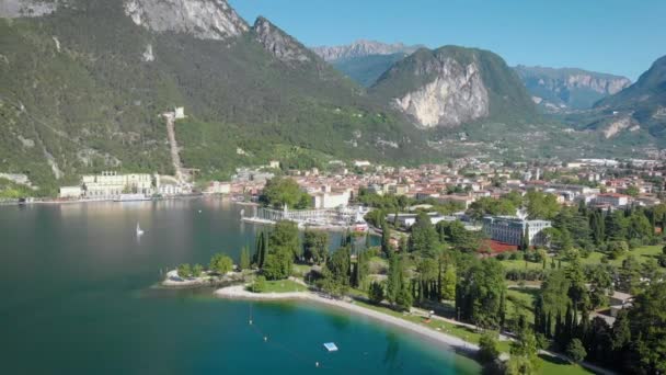 Tiro aéreo. Vista superior da bela cidade italiana de Riva Del Garda. Velhas casas baixas, ruas estreitas e o belo Lago de Garda . — Vídeo de Stock