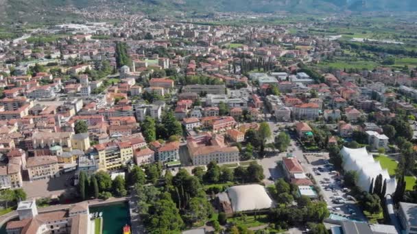 Un disparo aéreo. Vista superior de la hermosa ciudad italiana de Riva Del Garda. Casas bajas antiguas, calles estrechas y el hermoso lago de Garda . — Vídeo de stock