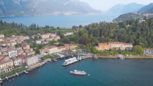 Vista aérea. En el marco se encuentra la famosa ciudad italiana de Bellagio. La ciudad balneario se encuentra en el centro del Lago de Como. Villas y casas antiguas están inscritas en un hermoso paisaje montañoso — Vídeo de stock