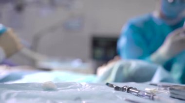 Diş kliniğinde ciddi bir ameliyat. Cerrah hastaya protez yerle bir eder. Mükemmel stil için koşullar yerine getirilir.