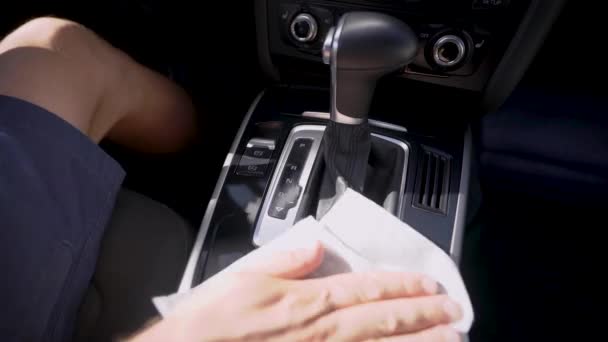 Driver is wiping panel of gear box in automobile, holding wet napkin in hand, closeup view inside car — Stock Video