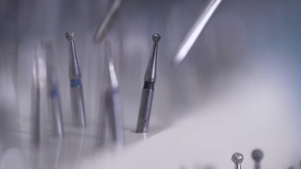 Hij is het nemen van polijsten nozzle door pincet, close-up in medische tandheelkundige kantoor, behandeling van cariës — Stockvideo