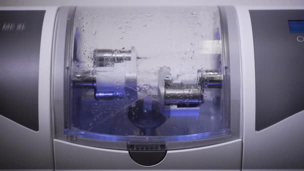 Zubní CNC stroj dělá zubní implantát, otáčení, leštění a mytí vodními toky, pohled na sraženku — Stock video