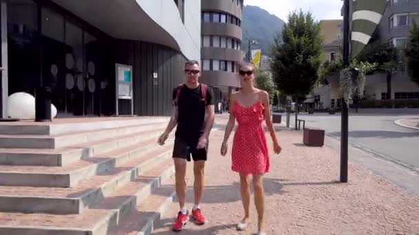 Pair of tourists are walking in small city, chatting and looking landmarks, man and woman are strolling — Stock Video