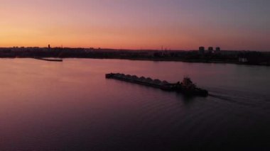 havadan görünüm. Su kanalında gün batımı. Kargo mavnası kilitlere doğru gidiyor. Bir dökme yük gemisi inşaat için ezilmiş taş büyük bir hacim taşır.