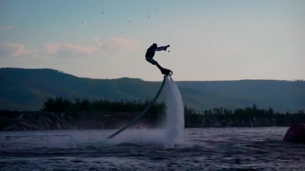 Estremo uomo amorevole sta guidando sul flyboard sul mare in vacanza estiva, sollevando da due flussi d'acqua — Video Stock