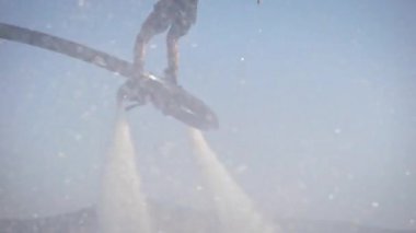 erkek flyboarder gündüz deniz yüzeyi üzerinde uçan, yukarı yükselterek ve su altında dalma, closeup görünümü