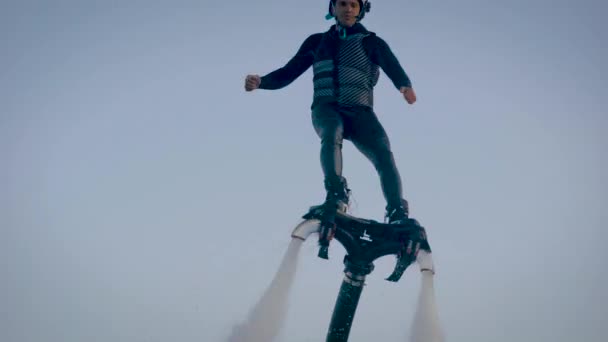 Deportista está practicando flyboarding en el agua, trucos de entrenamiento, girando en el aire, empujando por los flujos de agua — Vídeos de Stock