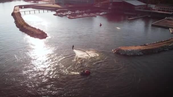 Mannelijke acrobaat trucs uitvoert op water Flyboard overdag, waterscooter drijvend in de buurt, luchtfoto — Stockvideo