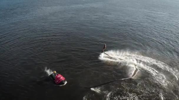 Flyboard-instructeur vliegt op en neer, voert Flip on Lake uit, bovenaanzicht van sporters in de zomerdag — Stockvideo