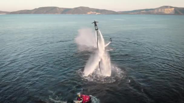 Dwa Extremals używa flyboards na jeziorze w letni dzień, wir i wykonywanie sztuczek, widok z lotu ptaka — Wideo stockowe