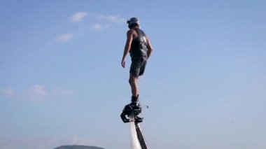 sporcu yaz tatilinde denizde flyboarding pratik yapıyor, mavi gökyüzüne karşı vücut yakın çekim