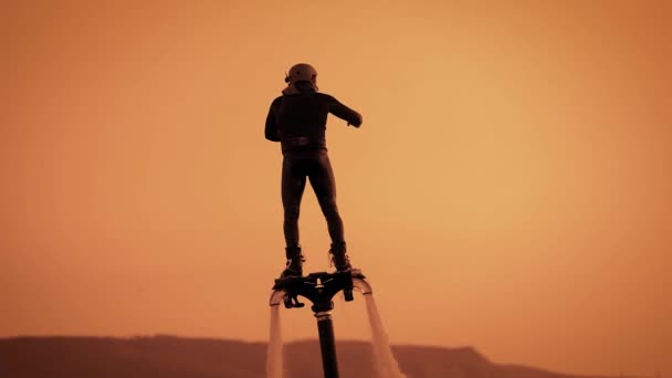 Extremal masculino é flyboarding em horário de pôr do sol no mar, placa de direção a pé, vista de perto da figura — Vídeo de Stock