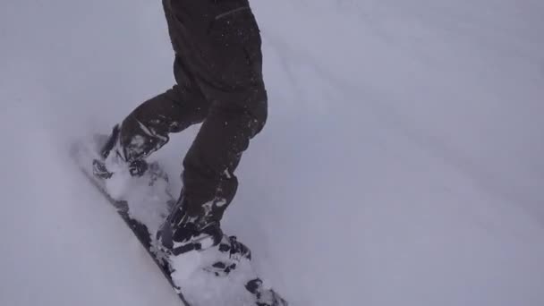 Nohy sebevědomého snowboardisty. Sportovní jízdy na bílém sněhu, extrémní sporty. — Stock video