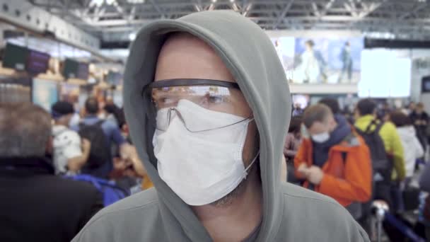 Egy férfi a nemzetközi repülőtér várótermében. Járvány esetén védőfelszerelést kell viselni.. — Stock videók