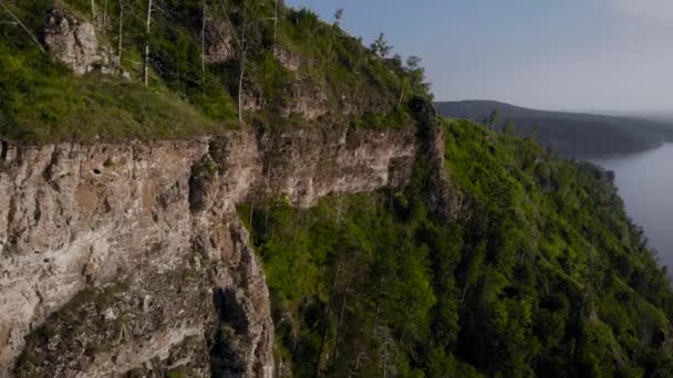 Vista desde arriba sobre la montaña rocosa y la orilla. Naturaleza veraniega en la franja central de Rusia. Acantilados de piedra y vegetación. — Vídeo de stock