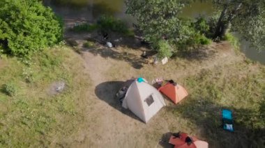 Tarlada küçük bir kamp. Turistler üç çadırı olan güzel doğal bir yerde durup yemek pişiriyor ve uzaklaşıyorlar..
