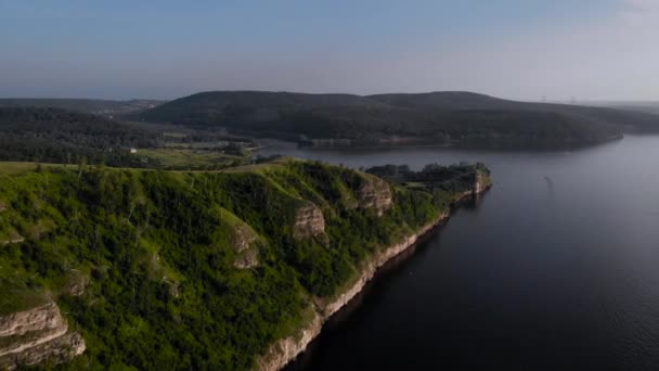 Vista desde arriba. Hermosa orilla de lago o mar, roca con árboles verdes. — Vídeos de Stock
