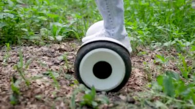 Kotlu ve kapüşonlu bir kız jiroskopa biniyor. Geleceğin elektrikli taşımacılığı ormanda yürümek için uygundur..