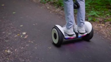 Ormanda jiroskopla gezen sıradan giyinmiş bir kız. Modern elektrik taşımacılığı.