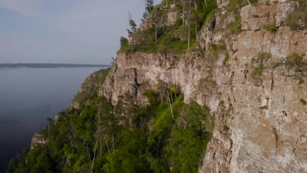 Vista desde arriba sobre la montaña rocosa y la orilla. Naturaleza veraniega en la franja central de Rusia. Acantilados de piedra y vegetación. — Vídeos de Stock