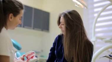 Kadın dişçi müşteriyle iletişim kurar.