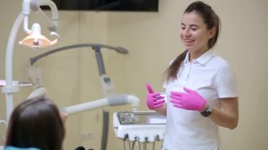 Diş hekimi ve hasta, arka planda tıbbi ekipmanlarla yapılan bir muayenede tedaviyi seçiyor
