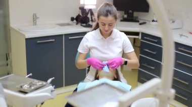 Kadın dişçi, dişçi muayenehanesinde metal parantez ile hastanın dişlerini kontrol ediyor. Tıp, dişçilik ve sağlık hizmetleri konsepti. Diş ekipmanları
