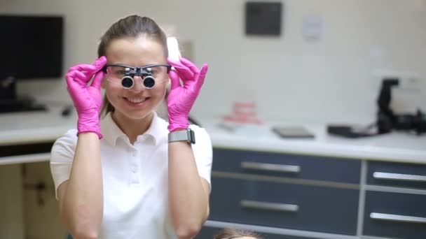 身穿白衣的牙科医生用专业设备治疗女孩的牙齿 — 图库视频影像