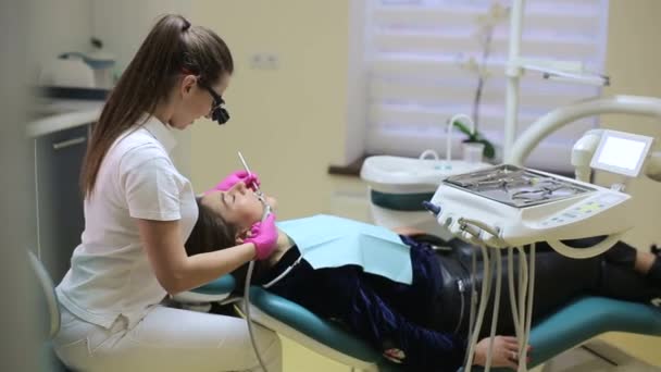 这个女孩是一名戴眼科眼镜的牙医 在一家专业诊所检查病人 女孩是牙医 — 图库视频影像