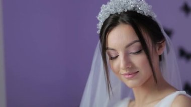 Beyaz duvar arkasında düğün buketi olan güzel bir gelin.