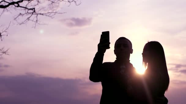 Silueta Zamilovaného Mladého Páru Který Užívá Západ Slunce Fotí Smartphonu — Stock video