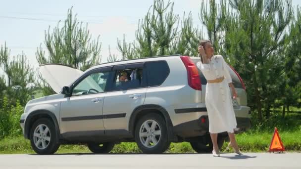 Γυναίκα Στέκεται Μπροστά Από Την Ανοιχτή Κουκούλα Ενός Χαλασμένου Αυτοκινήτου — Αρχείο Βίντεο