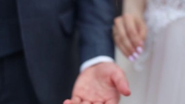 Gelin ve damat el ele tutuşuyorlar.