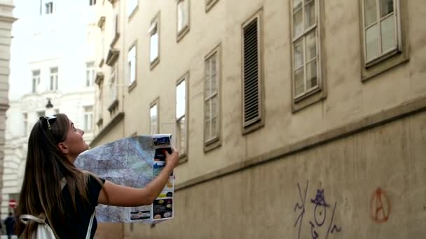 美丽的女孩正在寻找一个地址与地图上的老城市街道 有地图的重点妇女找到方向 — 图库视频影像