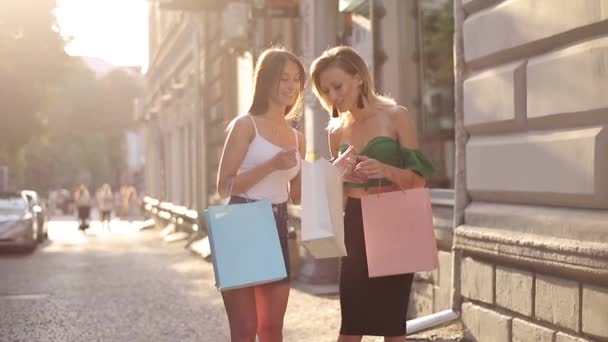 Two Happy Young Woman Showing Each Other Shopping Shopping Bags — Stock Video